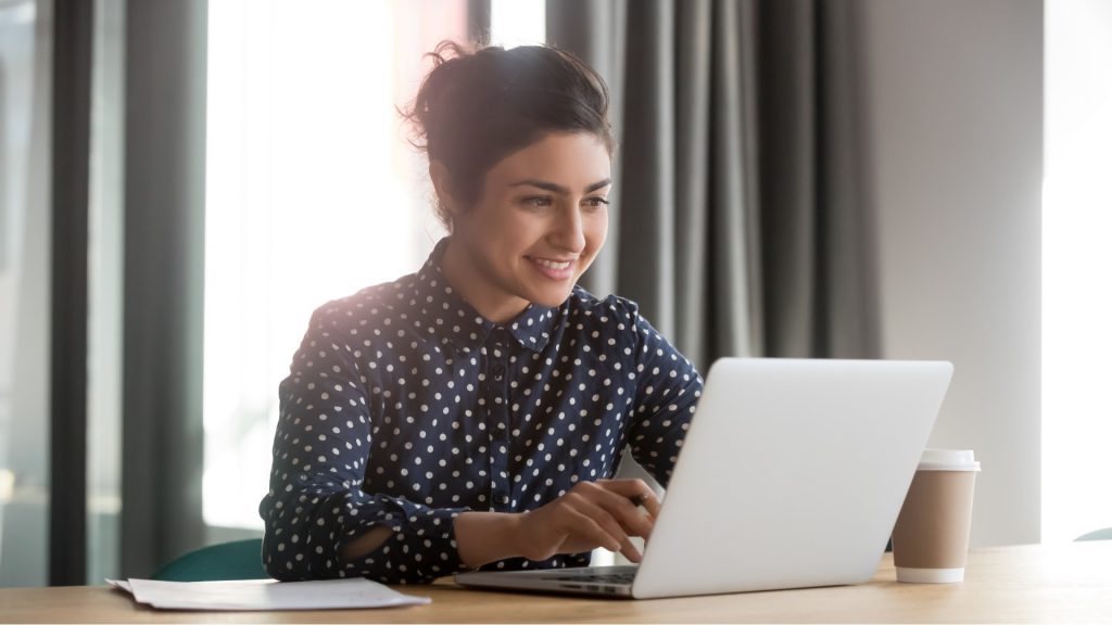 a person types on a laptop computer