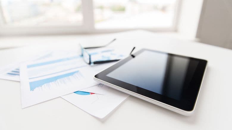 Close up of silver tablet and glasses resting on sales person's desk | Sales Enablement | LinkPoint360