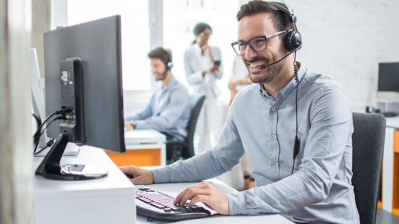 Salesman laughs while talking to customer on headset | Sales Enablement | LinkPoint360