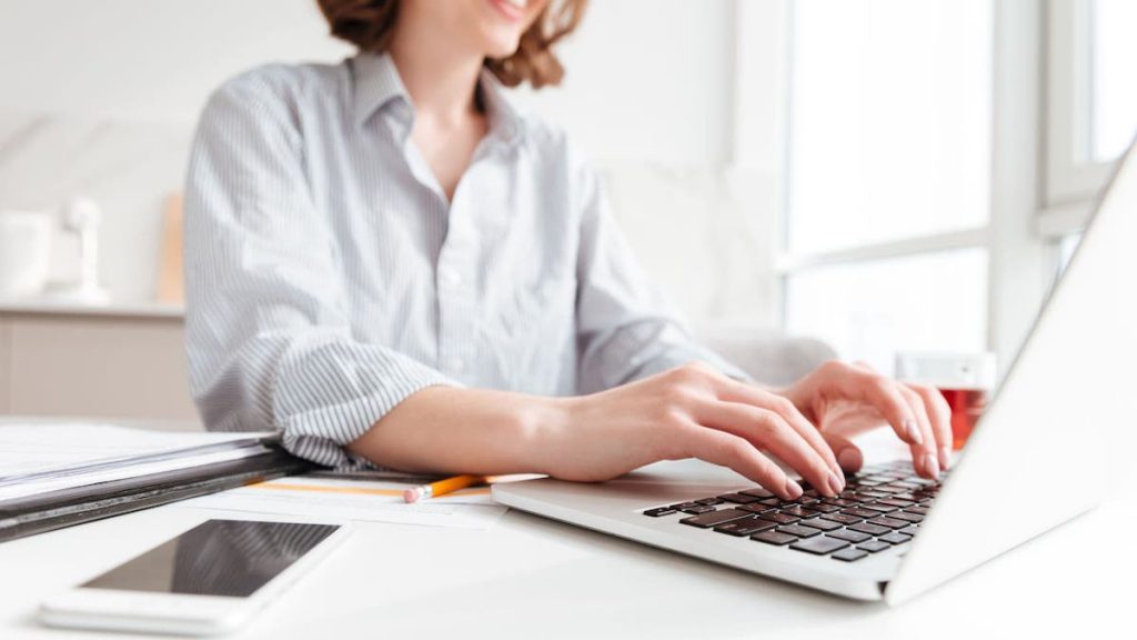 Salesforce user typing on a laptop while sitting at her desk | Linkpoint360