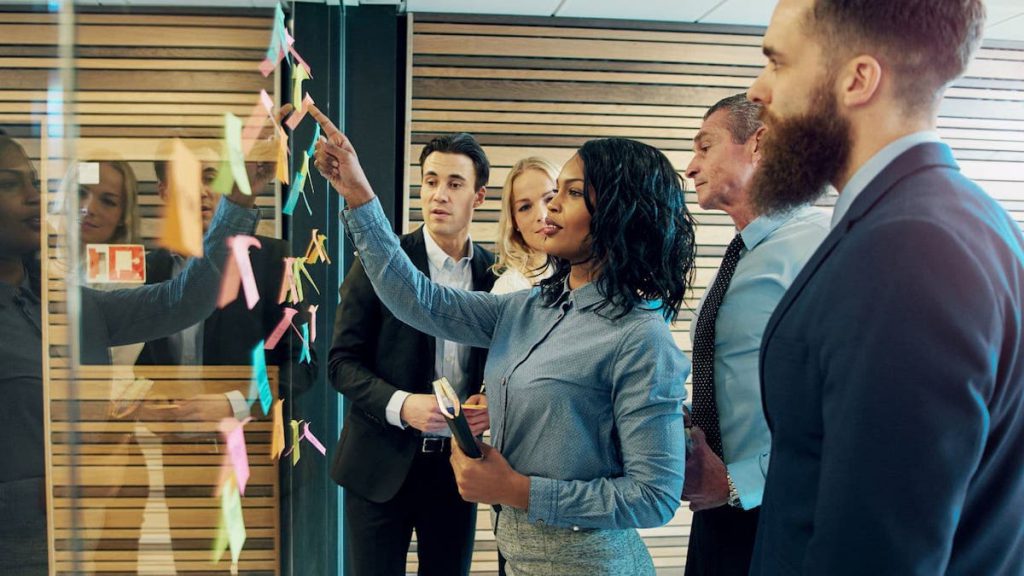 Sales team collaborates on wall of sticky notes during meeting | Linkpoint360