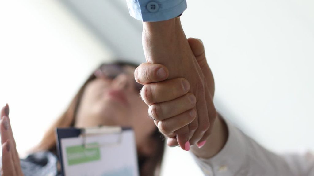 Close up of sales team members shaking hands | Linkpoint360