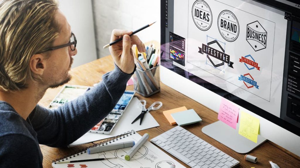 Man in black glasses designs brand logos on desktop computer | Linkpoint360