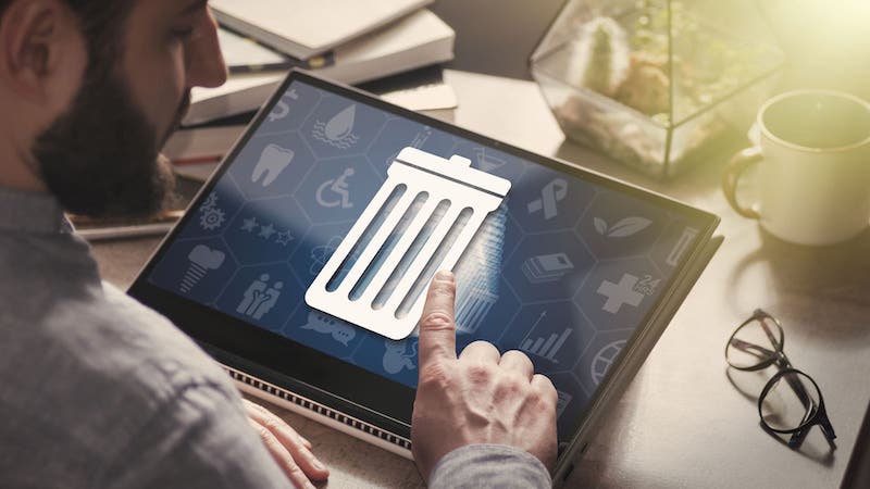 Close up of data manager tapping trash can icon on tablet | Organizing customer data in a CRM