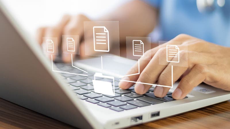 File icons hover over fingers typing on laptop keyboard | Organizing customer data in a CRM