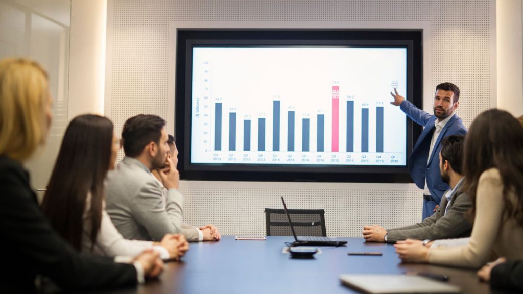 Sales Manager Points at Bar Graph While Presenting During Meeting | AI and Salesforce