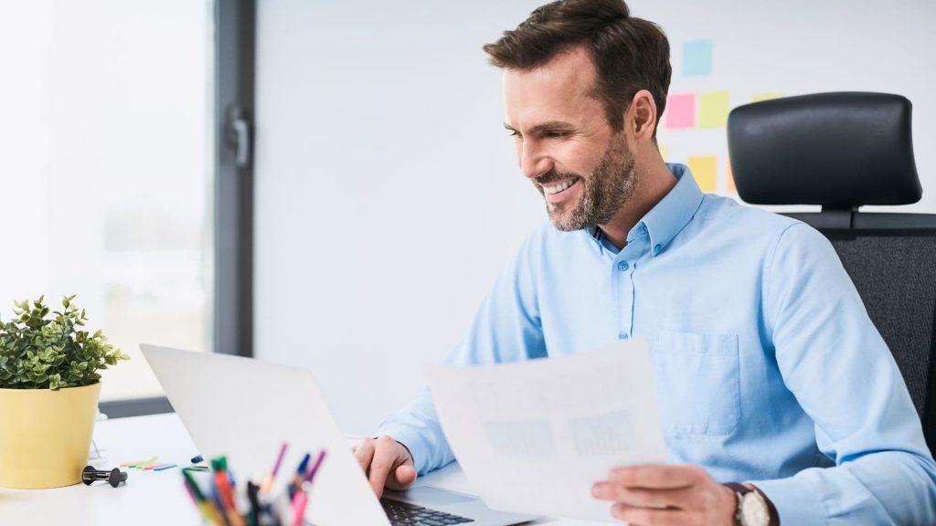 Sales Manager Smiles While Typing on Laptop Computer | AI and Salesforce