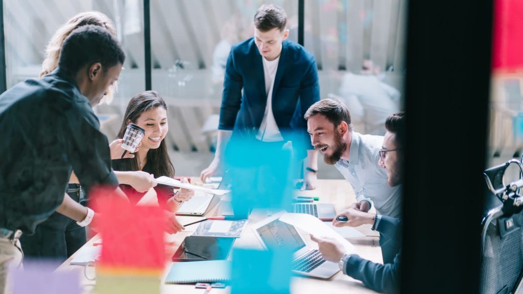 Sales Enablement Team Smiles During Meeting While Exchanging Papers | AI and Sales Enablement