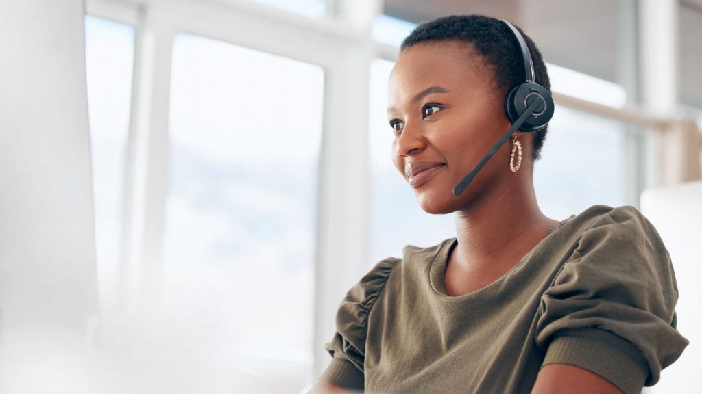 Salesperson Wearing Headset Smiles While Looking Off Into Distance | What is CRM Integration?