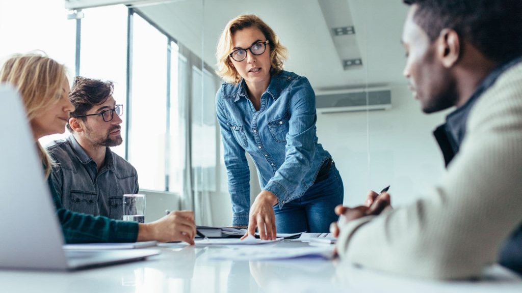 Sales Manager Leans Over Desk While Discussing Potential Leads During Meeting | What is CRM Integration?