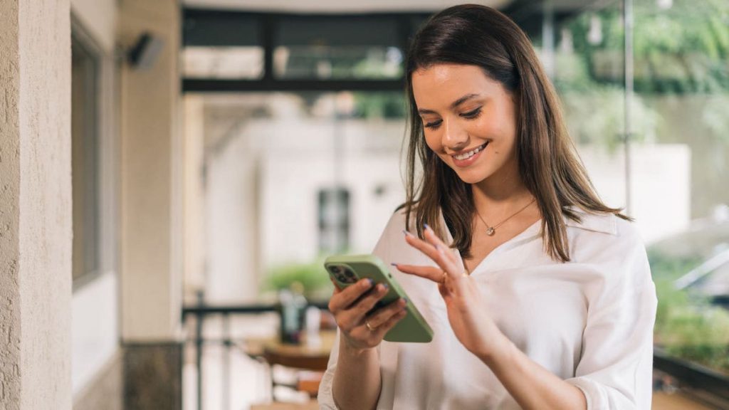 Smiling manager accesses customer data from her smartphone | Top 10 Salesforce Tips