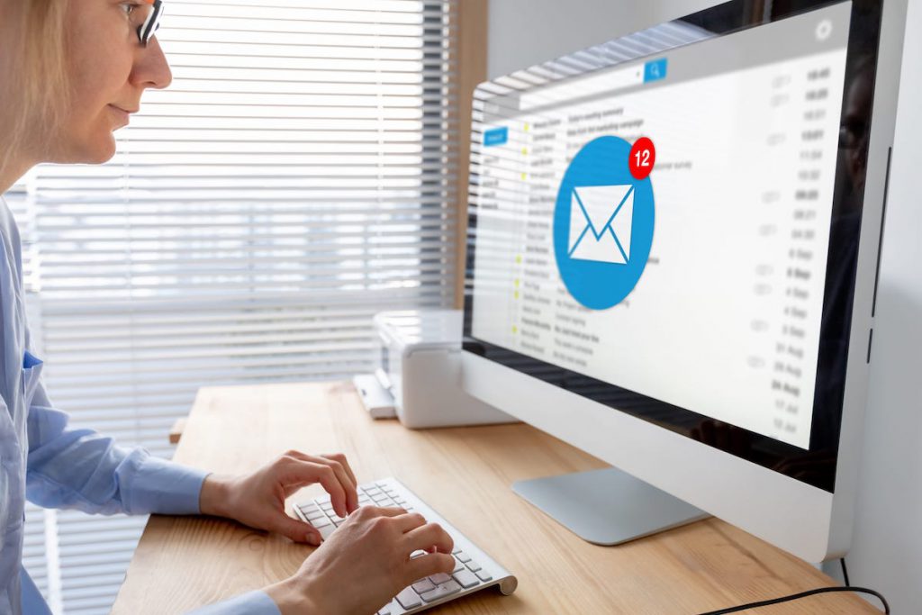 Woman opening her email on a desktop | CRM statistics